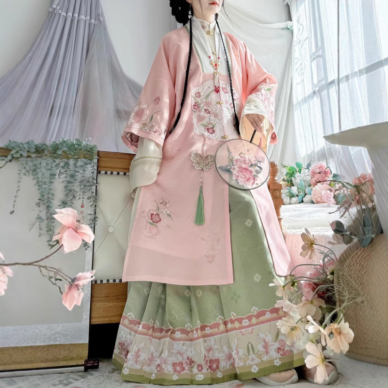 Hanfu szett: hosszú köntös álló gallérral és elöl nyíló felsőrész, hímzett; anyaga poliészter 30–50% regenerált cellulózrosttal; 2024 tavaszi kiadás