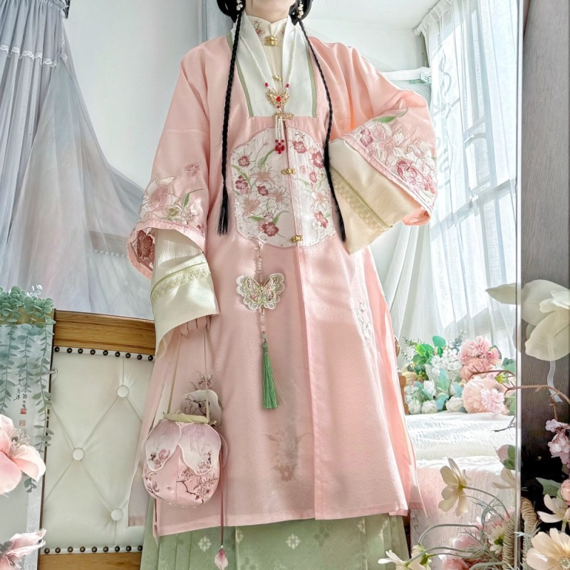 Hanfu szett: hosszú köntös álló gallérral és elöl nyíló felsőrész, hímzett; anyaga poliészter 30–50% regenerált cellulózrosttal; 2024 tavaszi kiadás