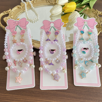 Gyerekeknek tengeri témájú ékszerkészlet: nyaklánc, karkötő, fülbevaló clip és gyűrű csillaghal és kagyló motívummal. Kézzel készített; anyag: műanyag/gyanta; medál anyaga: ötvözet; golyós lánc; többszintű dizájn; hosszabbító 10 cm alatt; Ocean sorozat