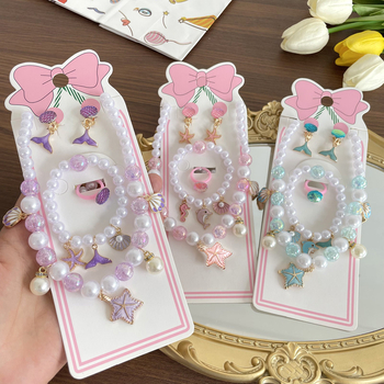 Gyerekeknek tengeri témájú ékszerkészlet: nyaklánc, karkötő, fülbevaló clip és gyűrű csillaghal és kagyló motívummal. Kézzel készített; anyag: műanyag/gyanta; medál anyaga: ötvözet; golyós lánc; többszintű dizájn; hosszabbító 10 cm alatt; Ocean sorozat