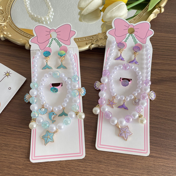 Gyerekeknek tengeri témájú ékszerkészlet: nyaklánc, karkötő, fülbevaló clip és gyűrű csillaghal és kagyló motívummal. Kézzel készített; anyag: műanyag/gyanta; medál anyaga: ötvözet; golyós lánc; többszintű dizájn; hosszabbító 10 cm alatt; Ocean sorozat