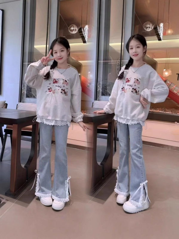 Dvostruki dječji komplet za djevojčice: pulover s dugim rukavom i okruglim izrezom te široke traperice; 85% pamuka s mekanim završetkom; pogodno za djevojčice preko 8 godina.