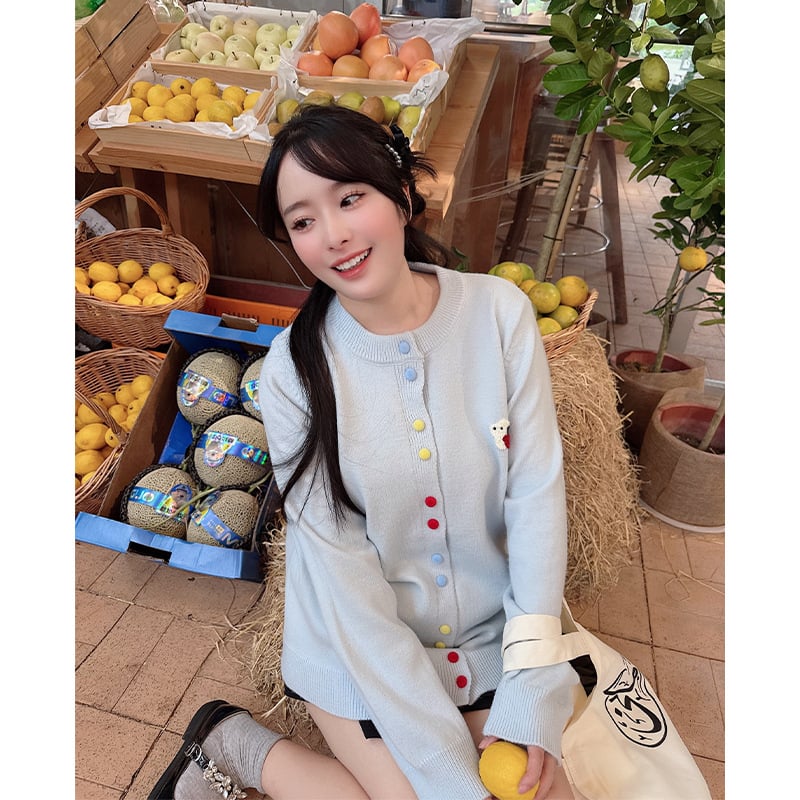 Pleten kardigan s izšivanjem i šarenim kopčicama na desnom ramenu, okrugli izrez, dugi rukavi; sastav materijala: akril i poliester 30-50%