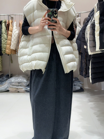 Ženski down vest, slobodan kroj, najlon materijal, zip, polukratak vrat, duljina 50–65 cm, sadržaj per 86–90%, 101–200 g punjenja