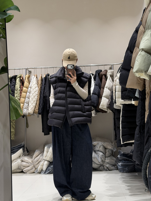 Ženski down vest, slobodan kroj, najlon materijal, zip, polukratak vrat, duljina 50–65 cm, sadržaj per 86–90%, 101–200 g punjenja