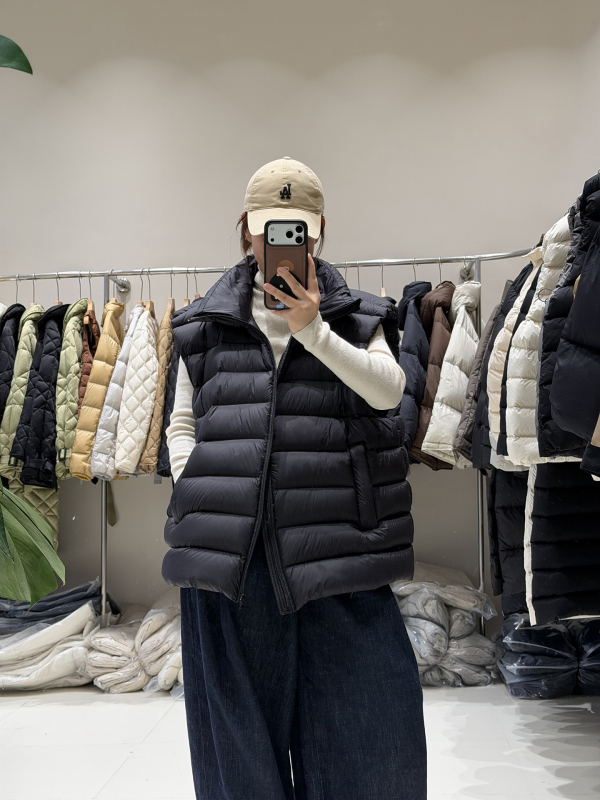 Ženski down vest, slobodan kroj, najlon materijal, zip, polukratak vrat, duljina 50–65 cm, sadržaj per 86–90%, 101–200 g punjenja