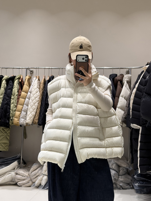 Ženski down vest, slobodan kroj, najlon materijal, zip, polukratak vrat, duljina 50–65 cm, sadržaj per 86–90%, 101–200 g punjenja