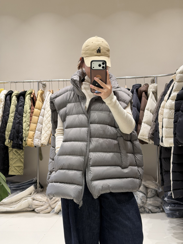 Ženski down vest, slobodan kroj, najlon materijal, zip, polukratak vrat, duljina 50–65 cm, sadržaj per 86–90%, 101–200 g punjenja