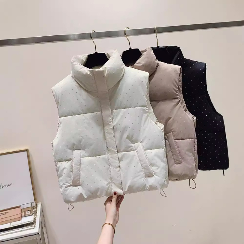 Ženska vesta sa stojećim ovratnikom i zatvaračem, punjenje od pernatog materijala, vanjski materijal poliester, uži kroj, normalna duljina, elegantan gradski stil
