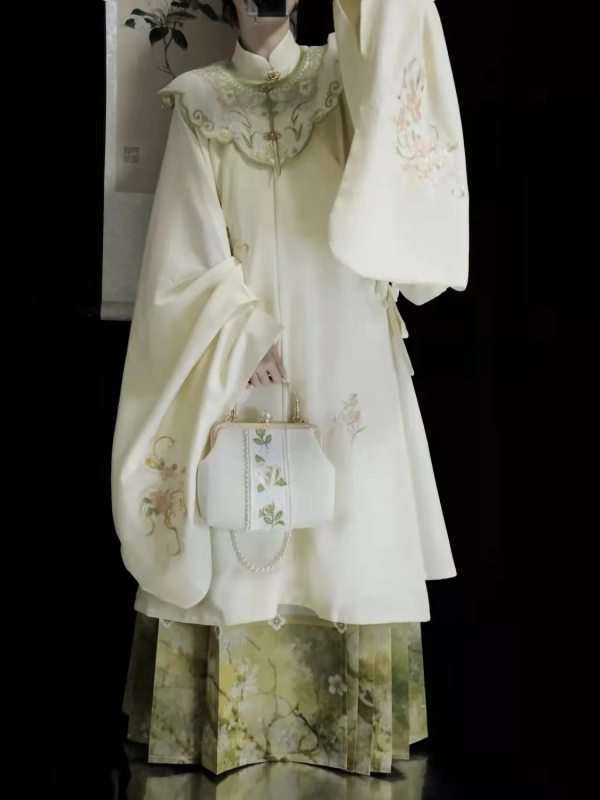 Hanfu set: izvezeni top s stojećim ovratnikom i oblačnim ramenima, suknja tipa horse-face; glavni materijal poliester 70–80%, sekundarni ispod 30%, jesensko-zimski Ming stil