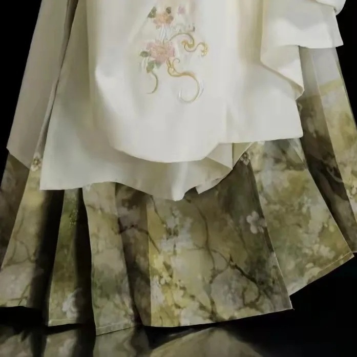 Hanfu set: izvezeni top s stojećim ovratnikom i oblačnim ramenima, suknja tipa horse-face; glavni materijal poliester 70–80%, sekundarni ispod 30%, jesensko-zimski Ming stil