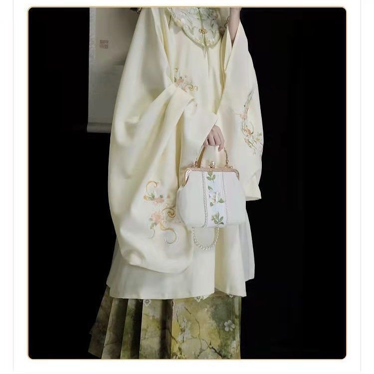 Hanfu set: izvezeni top s stojećim ovratnikom i oblačnim ramenima, suknja tipa horse-face; glavni materijal poliester 70–80%, sekundarni ispod 30%, jesensko-zimski Ming stil