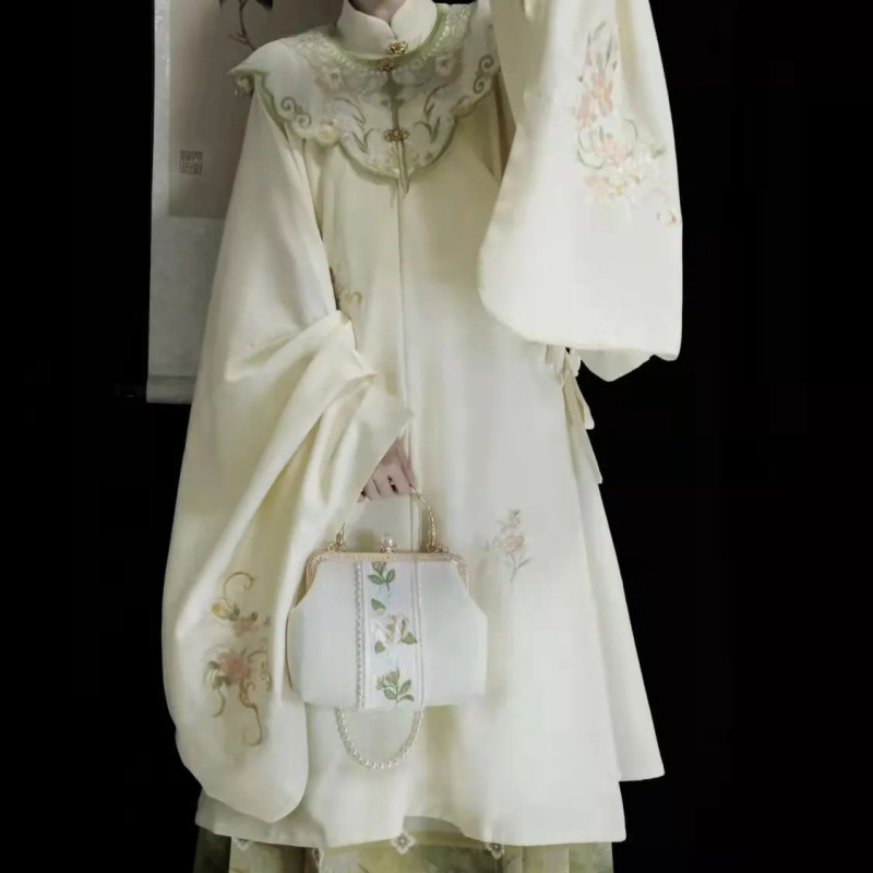 Hanfu set: izvezeni top s stojećim ovratnikom i oblačnim ramenima, suknja tipa horse-face; glavni materijal poliester 70–80%, sekundarni ispod 30%, jesensko-zimski Ming stil