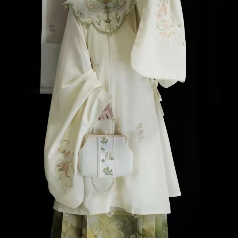 Hanfu set: izvezeni top s stojećim ovratnikom i oblačnim ramenima, suknja tipa horse-face; glavni materijal poliester 70–80%, sekundarni ispod 30%, jesensko-zimski Ming stil
