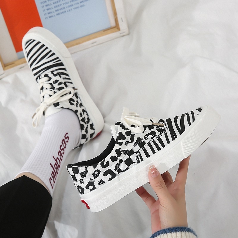 Platnene tenisice s leopardim uzorkom i panelima kariranog uzorka, vulkanizirana potplat, vezanje šnurikama (Gornji materijal: platno; Uzorak: leopard print; Materijal potplata: tele tetiva; Tehnologija potplata: vulkanizirana; Zatvaranje: vezice)