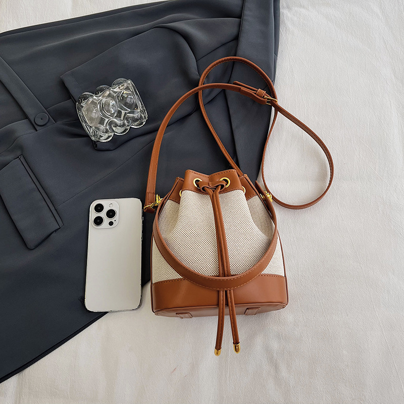 Sievietēm paredzēta kanna tipa soma, kokvilnas un lina materiāls, aizvērums auklai, iekšējā kabata ar rāvējslēdzēju, poliesteres oderė