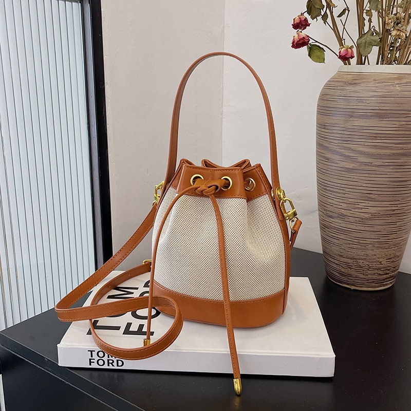 Sievietēm paredzēta kanna tipa soma, kokvilnas un lina materiāls, aizvērums auklai, iekšējā kabata ar rāvējslēdzēju, poliesteres oderė