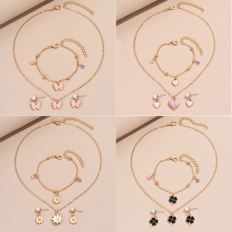 Gyerekeknek szánt ötvözet ékszerkészlet: fülbevaló, nyaklánc és karkötő motívumokkal (pillangó, szív, négylevelű lóhere és margaréta); anyag: ötvözet; lánc stílusa: O-lánc; medál anyaga: ötvözet; minta: virágok