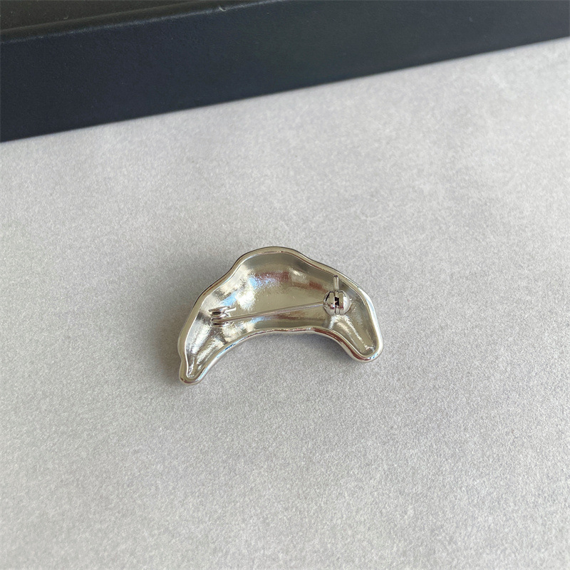 Καρφίτσα με σχέδιο κρουασάν και μοτίβα συνάστρων και ζωδίων· χαλκός, ηλεκτροπλατίωση