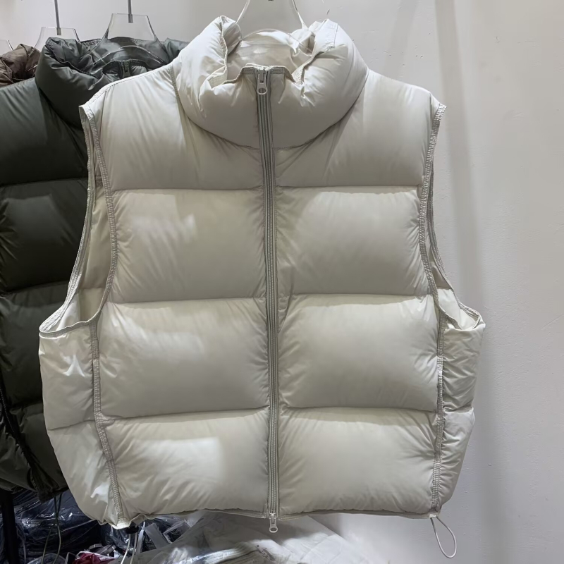 Ženski down prsluk, debeo najlonsko vanjski sloj, punilo od patjeg pera 51–55%, zatvarač sprijeda, stojeći ovratnik, kratka duljina (40–50 cm)