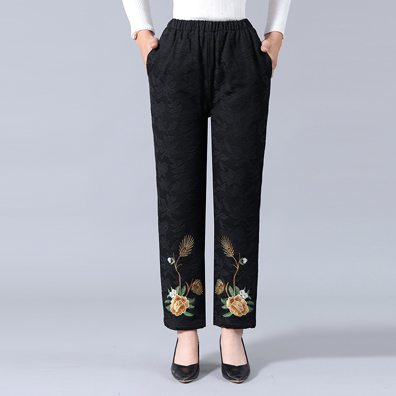 Vidurinei amžiaus moteriai žieminiai storesnės medvilninės kelnės su etnine siuvinėjimu – šiltos ir patogios, 70–80% medvilnė (kita iki 30%)