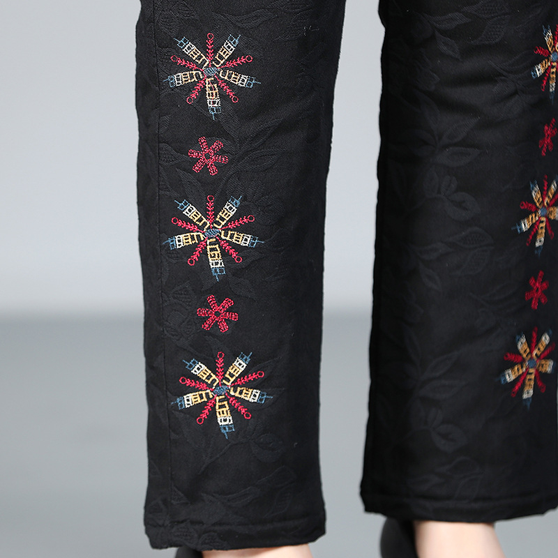 Vidurinei amžiaus moteriai žieminiai storesnės medvilninės kelnės su etnine siuvinėjimu – šiltos ir patogios, 70–80% medvilnė (kita iki 30%)