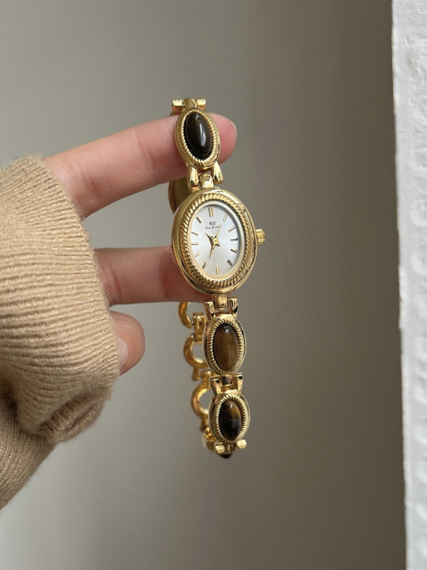 Ženski kvarcni sat s ovalnim brojčanikom, metalna narukvica, kućište od legure, spiralna krunica, srednjovjekovni stil