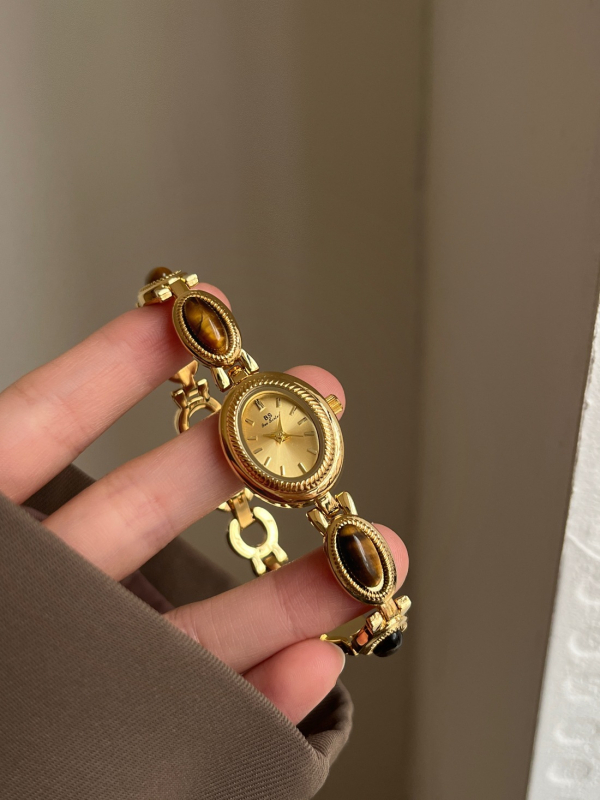 Ženski kvarcni sat s ovalnim brojčanikom, metalna narukvica, kućište od legure, spiralna krunica, srednjovjekovni stil