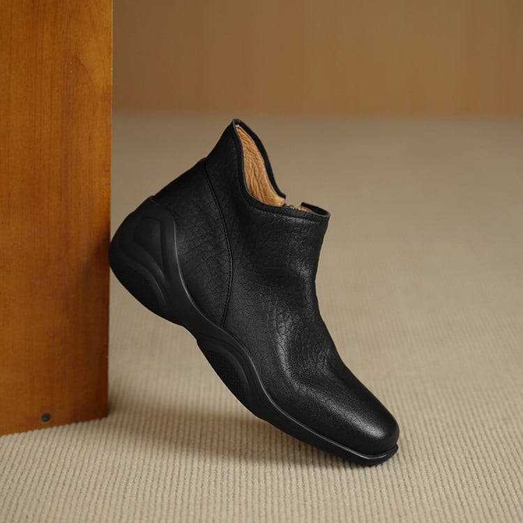 Sievietēm īsi zābaki no jēra ādas ar apaļu purnu, sānu rāvējslēdzēju, zemu platā papēdi, gumijas zole