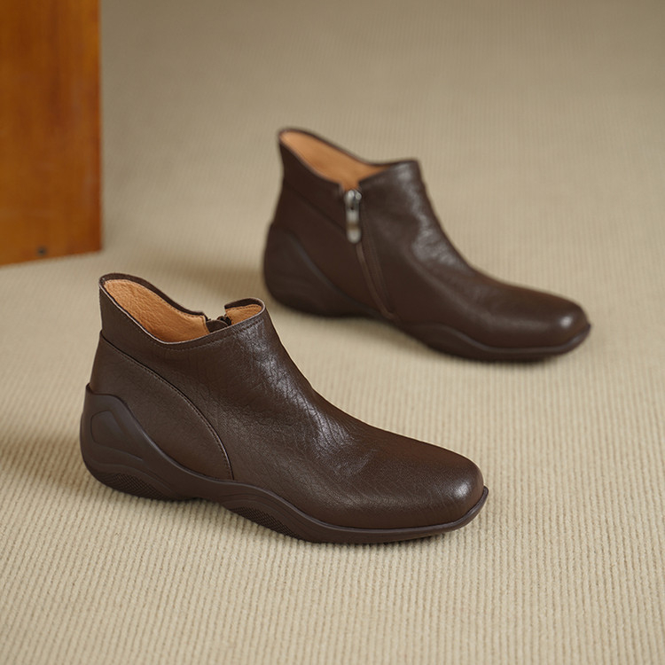 Sievietēm īsi zābaki no jēra ādas ar apaļu purnu, sānu rāvējslēdzēju, zemu platā papēdi, gumijas zole