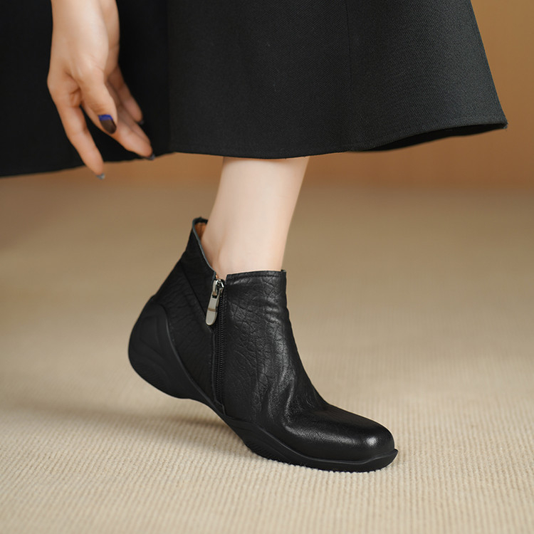 Sievietēm īsi zābaki no jēra ādas ar apaļu purnu, sānu rāvējslēdzēju, zemu platā papēdi, gumijas zole