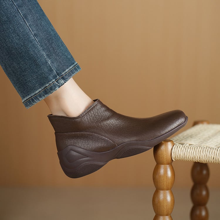 Sievietēm īsi zābaki no jēra ādas ar apaļu purnu, sānu rāvējslēdzēju, zemu platā papēdi, gumijas zole