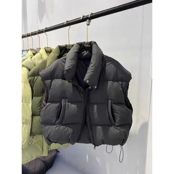 Naistele mõeldud lühike vatiinist vest, seisev krae ja tõmblukk — väline materjal: polüester, täidis: puuvill, pikkus 50–65 cm