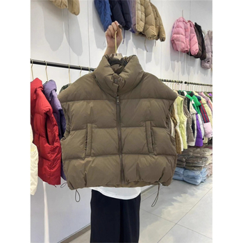 Naistele mõeldud lühike vatiinist vest, seisev krae ja tõmblukk — väline materjal: polüester, täidis: puuvill, pikkus 50–65 cm