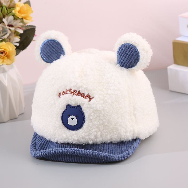 Zīdaiņu cepure no ait vilnas ar kupola formu un īsu malējumu; ausu aizsardzība; elpojoša, silta, pret vēju; 6–12 mēnešus un 1–2 gadus