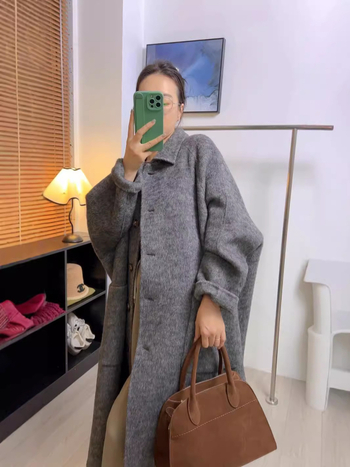 Moteriškas vilnos paltas kapės stiliumi – storas, laisvas kirpimas, ilgis daugiau nei 100 cm, kvadratinė apykaklė, dvigubas užsegimas; vilna 70–80% + Tencel 20–30%