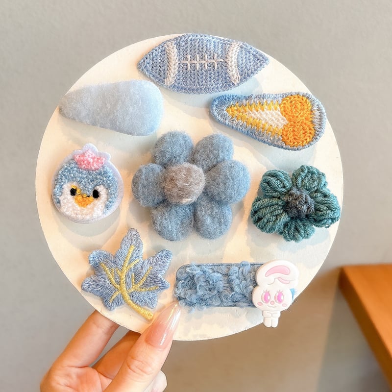 Lastele mõeldud juukseaksessuaaride komplekt — käsitöö kõrval klips lillmotiiviga joonistusstiilis, vanuserühm 3–10 aastat.