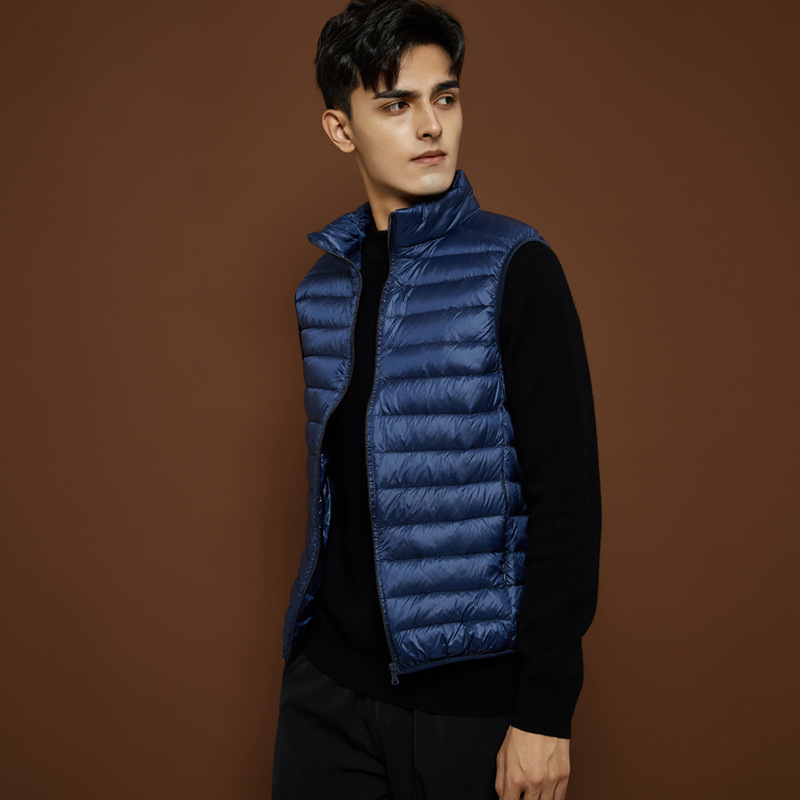 Férfiaknak tervezett vékony, könnyű téli toll mellény álló gallérral, fehér lud tollal töltve, 550 töltőerő, bélés és külső nylon anyag, karcsú szabás, több zseb