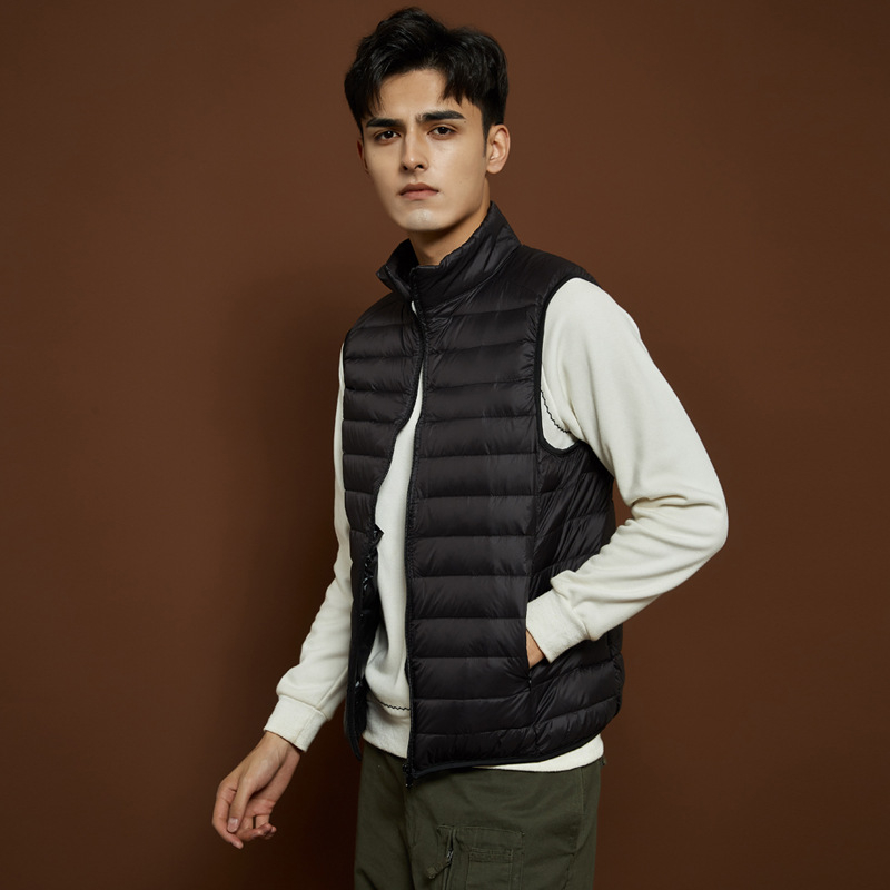 Férfiaknak tervezett vékony, könnyű téli toll mellény álló gallérral, fehér lud tollal töltve, 550 töltőerő, bélés és külső nylon anyag, karcsú szabás, több zseb