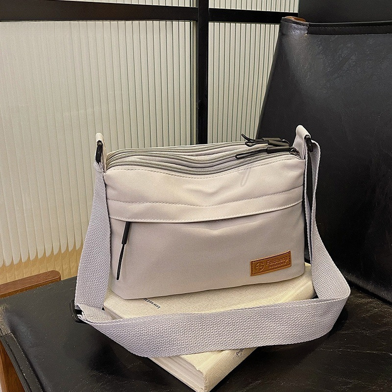 Crossbody torba, mali kvadratni dizajn, poliester materijal, poliester podstava, zatvaranje na zip, laminirani unutarnji džep, pogodno za slobodno vrijeme