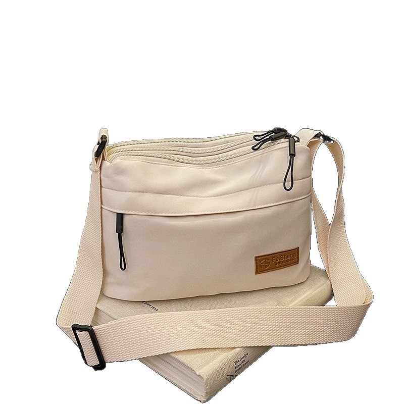Crossbody torba, mali kvadratni dizajn, poliester materijal, poliester podstava, zatvaranje na zip, laminirani unutarnji džep, pogodno za slobodno vrijeme