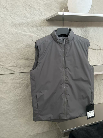 Poliészter töltésű ujjatlan mellény stand-up gallérral; anyag poliészter-keverék; oldalsó zsebek