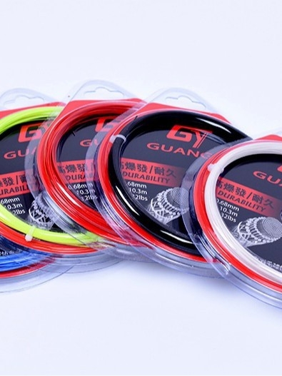 Badmintona raketes auklas – augsta spriegošana, izturīgas treniņu auklas; materiāls: sveķi + augstas izturības neilona šķiedra; zīmols Guangyu