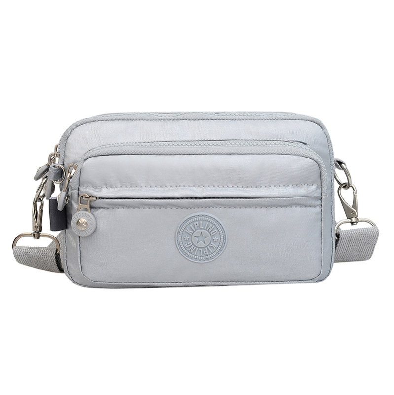 Moteriška crossbody rankinė — kasdienio stiliaus, universalus, lengva, vandeniui atspari nailonas; horizontali kvadratinė forma, užsegimas užtrauktuku, poliesterio pamušalas, viduje užtrauktuko kišenė ir telefono kišenė