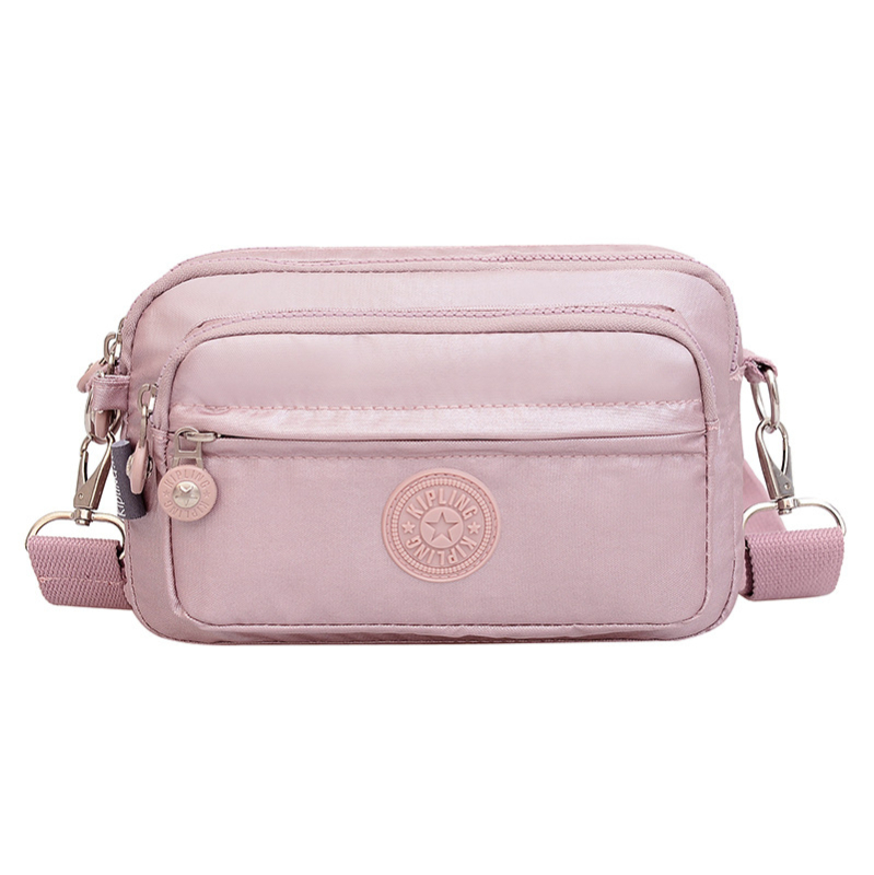 Moteriška crossbody rankinė — kasdienio stiliaus, universalus, lengva, vandeniui atspari nailonas; horizontali kvadratinė forma, užsegimas užtrauktuku, poliesterio pamušalas, viduje užtrauktuko kišenė ir telefono kišenė