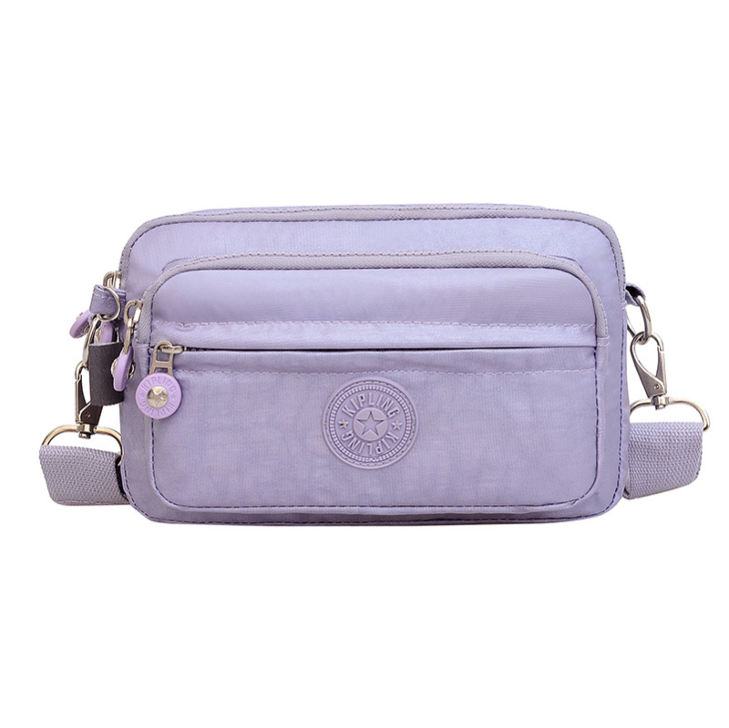 Moteriška crossbody rankinė — kasdienio stiliaus, universalus, lengva, vandeniui atspari nailonas; horizontali kvadratinė forma, užsegimas užtrauktuku, poliesterio pamušalas, viduje užtrauktuko kišenė ir telefono kišenė