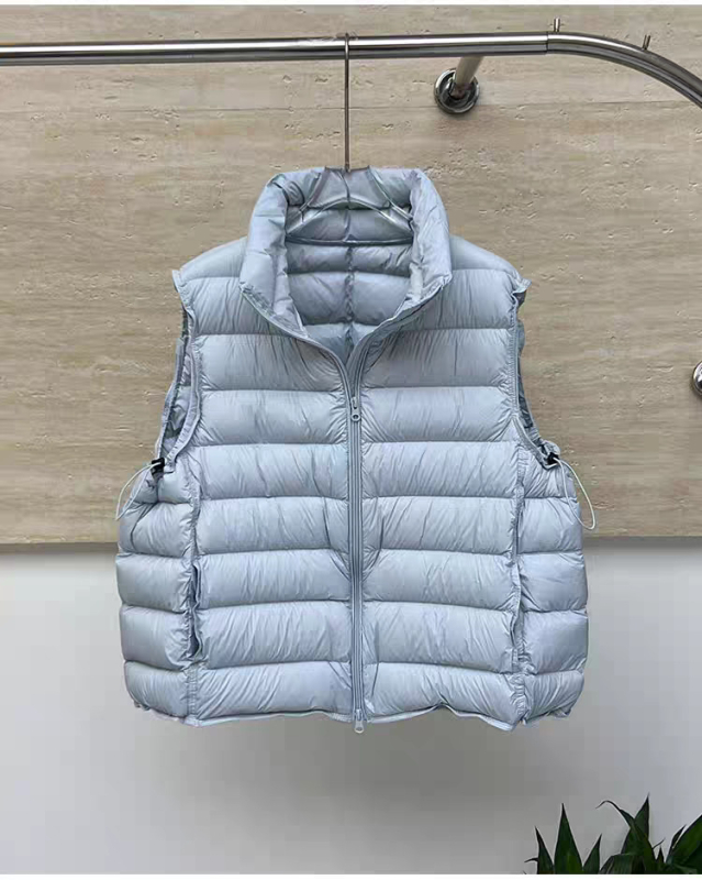 Ženski kratki vest s perjem – najlonsko vanjska ovojnica, sadržaj perja 50–55%, labav kroj, stojeći ovratnik, zatvarač sprijeda
