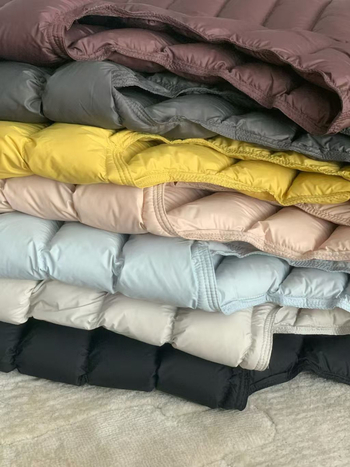 KALULI Sieviešu pūku veste ar neilona ārējo materiālu, pildījums no pīļu pūkām, pūku saturs 86–90%, īss garums (40–50 cm), rāvējslēdzējs