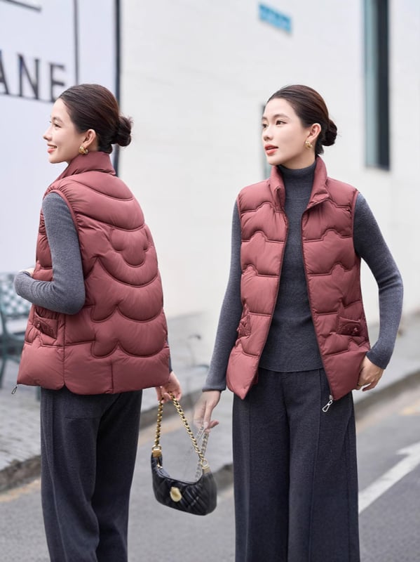 Sieviešu veste ar stāvošu apkakli; tievs piegriezums; īss garums 40–50 cm; rāvējslēdzējs; poliestera audums