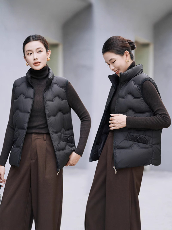 Sieviešu veste ar stāvošu apkakli; tievs piegriezums; īss garums 40–50 cm; rāvējslēdzējs; poliestera audums